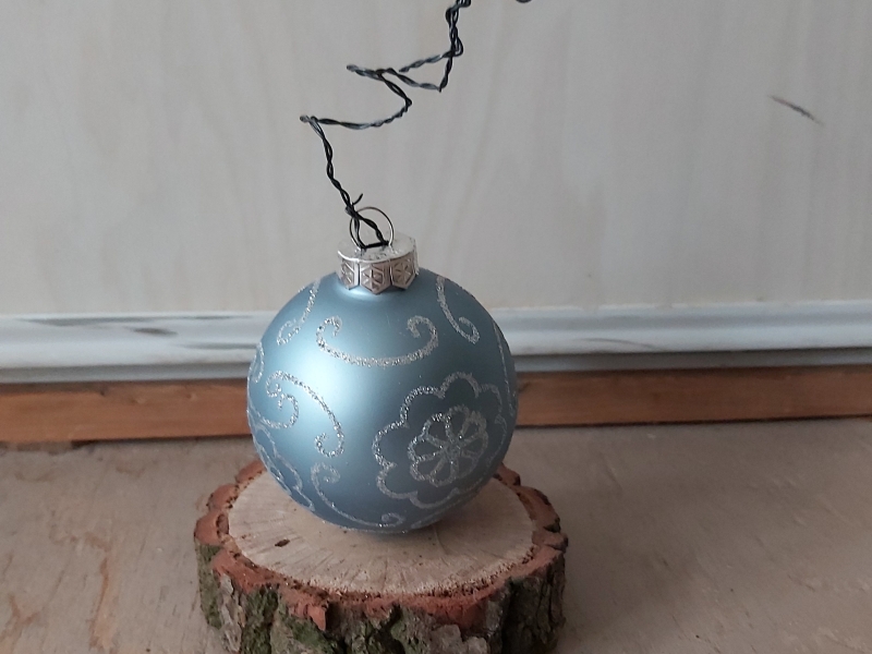 blauwe kerstbal op houten plankje